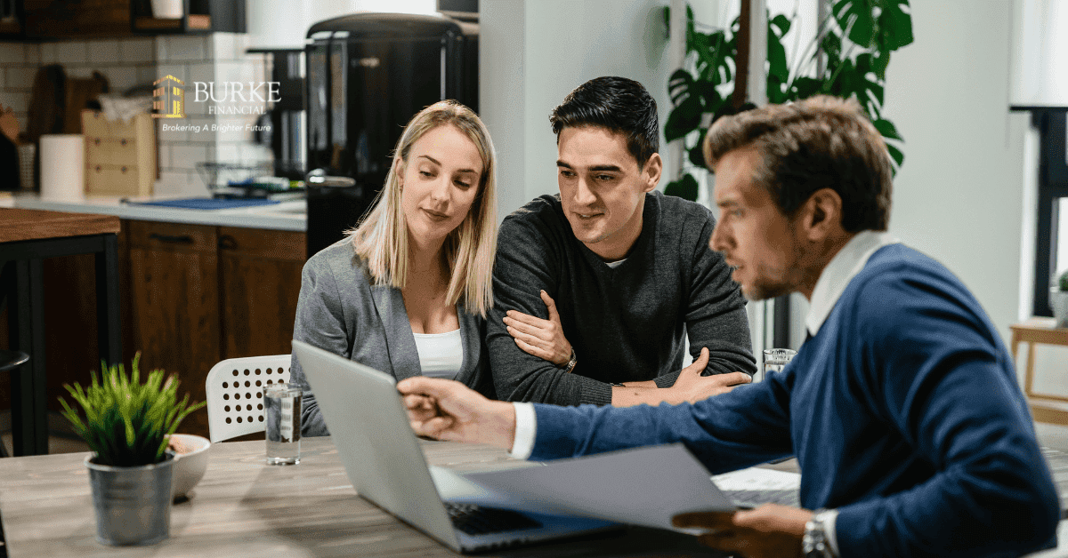 Mortgage broker reviewing paperwork with a Hamilton homeowner at a desk, demonstrating flexible, customized solutions beyond rigid bank processes