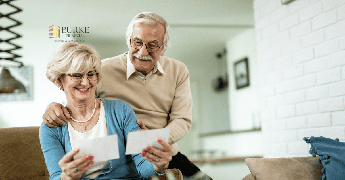 Smiling Ontario homeowners aged 55 and older standing outside their home, representing reverse mortgage eligibility.